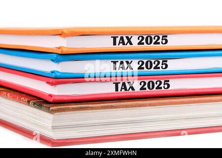 Symbole conceptuel Tax 2025. Copier l'espace. Tax 2025 mots écrits sur les extrémités des cahiers couchés les uns sur les autres sur un fond blanc Banque D'Images