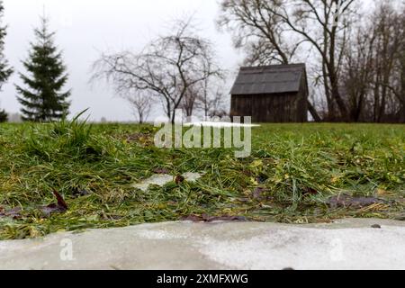 un petit hangar en bois dans la neige d'automne Banque D'Images