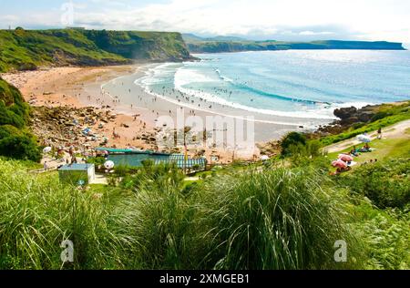 Les surfeurs plage Playa de los Locos sur une chaude journée de juillet d'été sur la côte nord de l'Espagne Suances Cantabrie Espagne Europe Banque D'Images