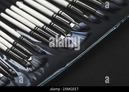 Tubes de peinture, brosses pour la peinture et la palette de couteaux sur fond en bois ancien. Gros plan Banque D'Images