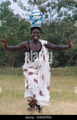Rwanda, Virunga Lodge. Volcanoes Safaris Partnership Trust (VSPT) manifestation culturelle traditionnelle. Danseuse féminine avec panier sur la tête. Banque D'Images