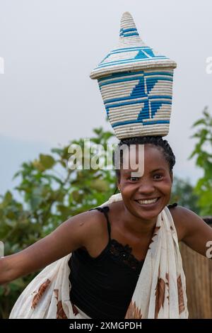 Rwanda, Virunga Lodge. Volcanoes Safaris Partnership Trust (VSPT) manifestation culturelle traditionnelle. Danseuse féminine avec panier sur la tête. Banque D'Images