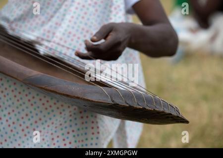 Rwanda, Virunga Lodge. Volcanoes Safaris Partnership Trust (VSPT) manifestations culturelles traditionnelles. Homme jouant un instrument à cordes en bois typique. Banque D'Images