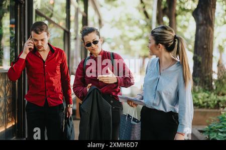 Hommes d'affaires marchant et parlant à l'extérieur dans une tenue décontractée tout en participant à une discussion animée Banque D'Images