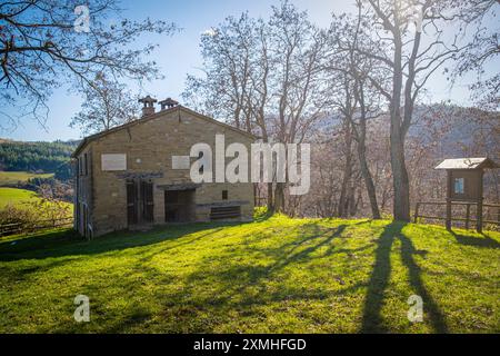 Femme avec sac à dos admirant la vieille maison dans les apennins. CA Cornio, Modigliana, Forlì, Emilie Romagne, Italie, Europe. Banque D'Images