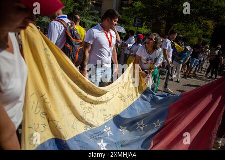 Madrid, Espagne. 28 juillet 2024. Les femmes portent un drapeau vénézuélien devant le centre de vote des Vénézuéliens vivant à Madrid, dans le quartier d'Aluche, à Madrid, lors des élections législatives pour élire le prochain chef d'État de la République bolivarienne du Venezuela. Près de 68 000 Vénézuéliens vivent à Madrid, mais seulement 9 000 ont réussi à s’inscrire et peuvent exercer leur droit de vote en personne depuis l’étranger. Crédit : SOPA images Limited/Alamy Live News Banque D'Images