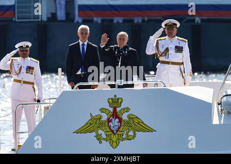 Saint-Pétersbourg, Russie. 28 juillet 2024. Le président russe Vladimir Poutine (au centre) participe à un défilé naval sur un bateau sur la Neva avec le ministre russe de la Défense Andreï Belousov (à gauche) à Pétersbourg. Le dernier dimanche de juillet, le Saint-Pétersbourg célébrera traditionnellement la Journée de la Marine. Les cérémonies commencent traditionnellement par un défilé de navires. Cette année, pour la première fois en 8 ans, le défilé aura lieu sans l’unité de Cronstadt. Le président russe Vladimir Poutine prononcera traditionnellement un discours sur la place du Sénat à Pétersbourg. Crédit : SOPA images Limited/Alamy Live Banque D'Images