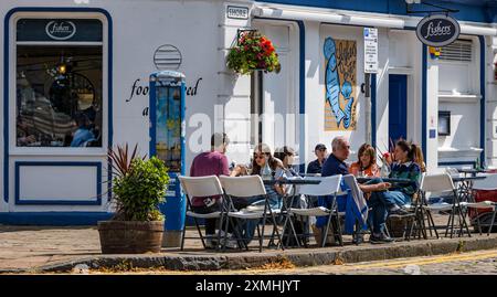 Leith, Édimbourg, Écosse, Royaume-Uni, 28 juillet 2024. Météo britannique : avec l'arrivée de l'été enfin, les gens profitent des bars et des vues dans l'endroit le plus branché de la ville pour vivre. Sur la photo : tables de café au restaurant de fruits de mer Fisher's. Crédit : Sally Anderson/Alamy Live News Banque D'Images