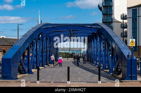 Leith, Édimbourg, Écosse, Royaume-Uni, 28 juillet 2024. Météo britannique : avec l'arrivée de l'été enfin, les gens profitent du temps ensoleillé dans l'endroit le plus branché de la ville pour vivre. Sur la photo : le pont Victoria en fonte récemment restauré à l'entrée de l'eau de la rivière Leith est un endroit pittoresque pour une promenade. Crédit : Sally Anderson/Alamy Live News Banque D'Images