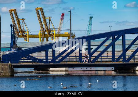 Leith, Édimbourg, Écosse, Royaume-Uni, 28 juillet 2024. Météo britannique : avec l'arrivée de l'été enfin, les gens profitent du temps ensoleillé dans l'endroit le plus branché de la ville pour vivre. Sur la photo : le pont Victoria en fonte récemment restauré à l'entrée de l'eau de la rivière Leith est un endroit pittoresque pour une promenade. Crédit : Sally Anderson/Alamy Live News Banque D'Images