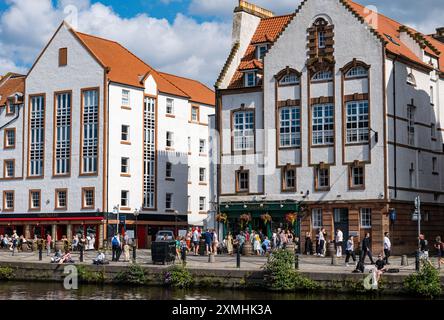 Leith, Édimbourg, Écosse, Royaume-Uni, 28 juillet 2024. Météo britannique : avec l'arrivée de l'été enfin, les gens profitent des bars et des vues dans l'endroit le plus branché de la ville pour vivre. Sur la photo : les gens appréciant les pubs et cafés au bord de la rivière sur la rive. Crédit : Sally Anderson/Alamy Live News Banque D'Images