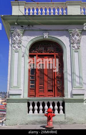 541 bouche d'incendie rouge devant une fenêtre rouge, mur blanc et vert menthe de la maison éclectique, rue Santa Rita et coin Padre Pico. Santiago-Cuba. Banque D'Images