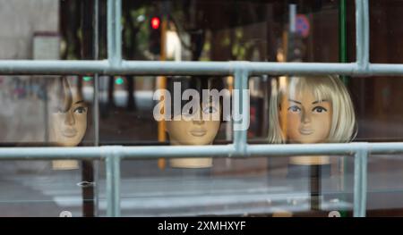 Vitrine avec trois têtes de mannequin. Banque D'Images