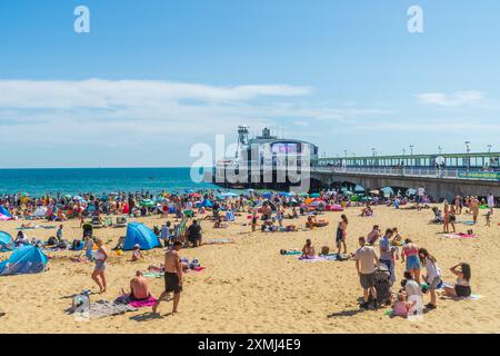 East Cliff Beach, Bournemouth, Royaume-Uni - 28 juillet 2024 : bains de soleil sur la plage de sable fin profitant du temps chaud en face de la jetée de Bournemouth. Banque D'Images