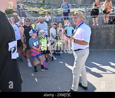 Devon, Royaume-Uni. 28 juillet 2024. Le jour le plus chaud de l'année Cllr David Ruffle a voté comme maire de Lyme Regis lors de la première réunion du nouveau conseil municipal de Lyme Regis en mai 2024, a introduit le début d'une course amusante se déroulant sur le front de mer. Crédit photo : Robert Timoney/Alamy Live News Banque D'Images