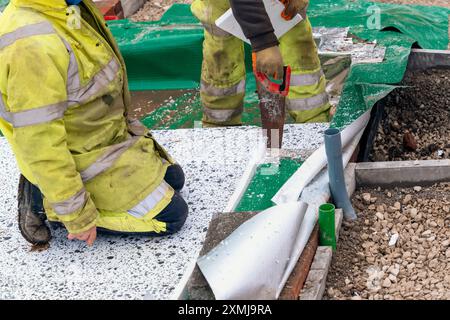 Constructeur plaçant des panneaux isolants de polystyrène sur la membrane d'étanchéité pendant la construction de plancher. Concept d'économie d'énergie Banque D'Images