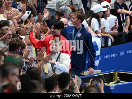 28 juillet 2024 ; Jeux Olympiques de Paris, Paris, France, jour 3; finales de natation à la Defence Arena, les médaillés célèbrent avec la foule, Leon Marchand, de France, reçoit la médaille d'or au médaillé individuel du 100 m avec MATSUSHITA Tomoyuki la médaille d'argent et FOSTER Carson le crédit de bronze : action plus Sports images/Alamy Live News Banque D'Images