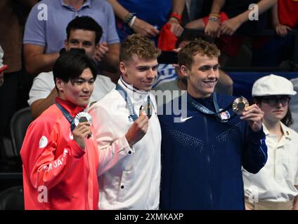 28 juillet 2024 ; Jeux Olympiques de Paris, Paris, France, jour 3; finales de natation à la Defence Arena, Leon Marchand, de France, reçoit la médaille d'or au 100m médaillé individuel avec MATSUSHITA Tomoyuki la médaille d'argent et FOSTER Carson le crédit de bronze : action plus Sports images/Alamy Live News Banque D'Images