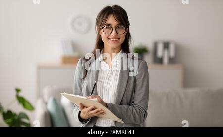 Bonne professionnelle moyenne-orientale femme psychologue regardant et souriant à la caméra, travaillant dans un bureau moderne Banque D'Images