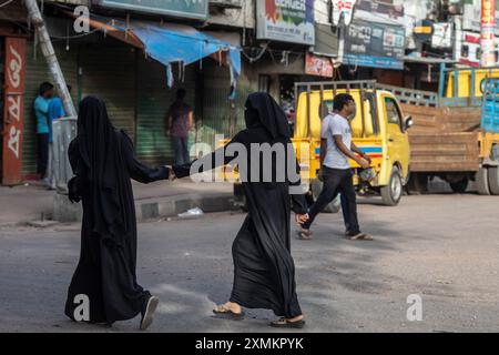 Dhaka, Bangladesh. 21 juillet 2024. Les filles traversent la rue dans le quartier de Mohammadpur pendant un couvre-feu national. Le gouvernement du Bangladesh a décrété un couvre-feu dans tout le pays pour une durée indéterminée et a déployé une armée pour aider l'administration civile. (Photo de Sazzad Hossain/SOPA images/SIPA USA) crédit : SIPA USA/Alamy Live News Banque D'Images