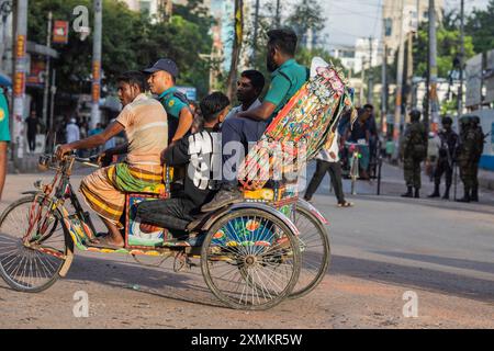 Dhaka, Bangladesh. 21 juillet 2024. Police du Bangladesh vue assise sur le pousse-pousse d'un résident pendant un couvre-feu national le gouvernement du Bangladesh a décrété un couvre-feu dans tout le pays pour une durée indéterminée et a déployé une armée pour aider l'administration civile. (Photo de Sazzad Hossain/SOPA images/SIPA USA) crédit : SIPA USA/Alamy Live News Banque D'Images