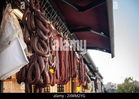 Cette image capture une exposition traditionnelle de saucisses turques, connues localement sous le nom de sucuk, suspendues à la vente à un étal de marché à Istanbul, en Turquie. L'ima Banque D'Images