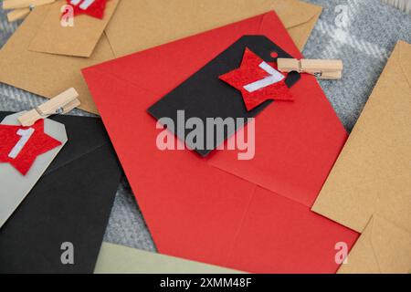Numéro sur les enveloppes d'artisanat notes avec des tâches avant les vacances de Noël. Femme faisant du papier kraft pour calendrier de l'Avent fait à la main fait de vos propres mains étape par étape bricolage artisanat faites-le vous-même Banque D'Images