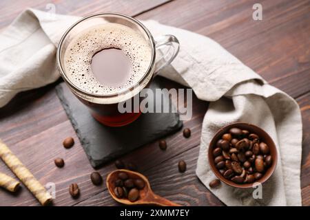 Buvez des montagnes russes avec une tasse de café, des rouleaux de galettes et des haricots sur une table en bois Banque D'Images