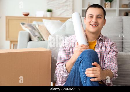 Jeune homme avec un film étirable à la maison Banque D'Images