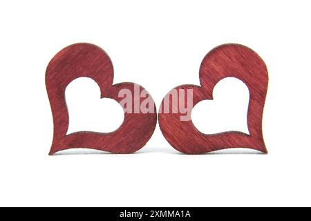 Gros plan de deux coeurs en bois rouge symbolisant l'amour, le romantisme et la convivialité. Parfait pour la Saint-Valentin, les anniversaires et les thèmes romantiques. Banque D'Images