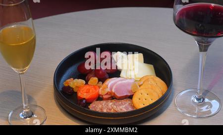 Tableau de charcuterie élégant avec assortiment de fromages, viandes et fruits, Banque D'Images