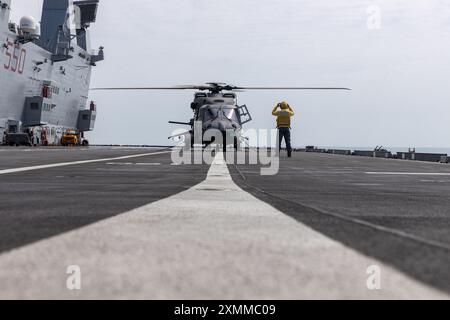 Un matelot de la marine italienne sécurise un NH-90 de la marine italienne sur le pont d'atterrissage du porte-avions italien ITS Cavour lors de l'exercice Pitch Black 24, dans la mer de Timor, le 25 juillet 2024. L’exercice Pitch Black 24 est le plus important des 43 ans d’histoire de l’exercice et rassemble 20 pays participants, plus de 140 avions du monde entier et plus de 4000 membres du personnel. L'emplacement de l'exercice Black 24 permet à Marine Rotational Force - l'élément de combat aérien de Darwin 24.3 (Marine Medium Tiltrotor Squadron 268 (renforcé), d'intégrer les MV-22B Ospreys et les capacités de combat aérien dans un cadre mixte Banque D'Images