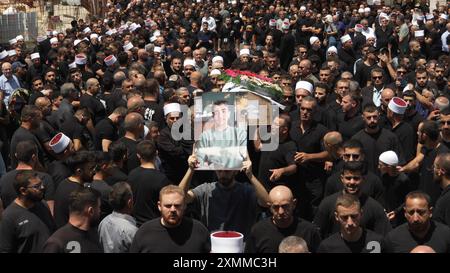 MAJDAL SHAMS, ISRAËL - JUILLET 28 : des membres de la communauté druze assistent aux funérailles des victimes d'une attaque à la roquette récente le 28 juillet 2024 à Majdal Shams, en Israël. L’attaque, qui a eu lieu dans la soirée du 27 juillet 2024, impliquait une roquette de fabrication iranienne avec une ogive de 50 kilogrammes, tirée depuis le Liban. La roquette a frappé un terrain de football dans la communauté druze de Majdal Shams, sur le plateau du Golan, faisant douze morts parmi les enfants et plus de trente blessés. Cet incident représente l’événement le plus meurtrier sur le front nord depuis le 8 octobre 2023, lorsque le Hezbollah a commencé sa république de chine Banque D'Images