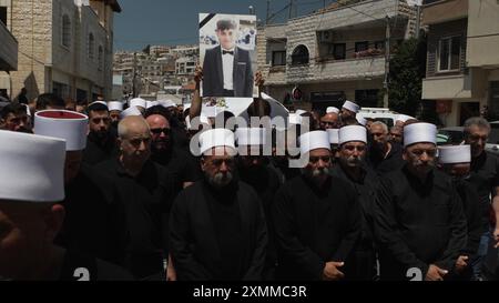 MAJDAL SHAMS, ISRAËL - JUILLET 28 : des membres de la communauté druze assistent aux funérailles des victimes d'une attaque à la roquette récente le 28 juillet 2024 à Majdal Shams, en Israël. L’attaque, qui a eu lieu dans la soirée du 27 juillet 2024, impliquait une roquette de fabrication iranienne avec une ogive de 50 kilogrammes, tirée depuis le Liban. La roquette a frappé un terrain de football dans la communauté druze de Majdal Shams, sur le plateau du Golan, faisant douze morts parmi les enfants et plus de trente blessés. Cet incident représente l’événement le plus meurtrier sur le front nord depuis le 8 octobre 2023, lorsque le Hezbollah a commencé sa république de chine Banque D'Images