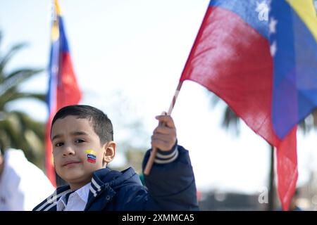 Santiago, Chili. 28 juillet 2024. Un garçon avec un drapeau vénézuélien peint sur son visage participe à l'attente des résultats de l'élection présidentielle vénézuélienne à Santiago, au Chili, le 28 juillet 2024. Des milliers de Vénézuéliens sont arrivés à l'ambassade vénézuélienne à Santiago du Chili pour participer aux élections depuis l'étranger. (Photo de Jesus Martinez/Sipa USA) crédit : Sipa USA/Alamy Live News Banque D'Images