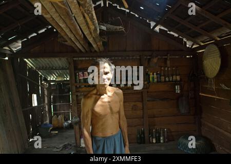 Portrait de Daniel Rajang, ancien tumenggung (chef traditionnel) de la communauté Orung Da'an Dayak, dans sa cabane agricole du village de Nanga Raun, Kalis, Kapuas Hulu, Kalimantan occidental, Indonésie. La communauté Orung Da'an avait autrefois la plus longue maison longue de Kalimantan, mais elle a disparu après un accident d'incendie il y a quelques décennies, a-t-il dit. Banque D'Images