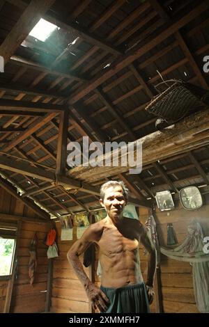 Portrait de Daniel Rajang, ancien tumenggung (chef traditionnel) de la communauté Orung Da'an Dayak, dans sa cabane agricole du village de Nanga Raun, Kalis, Kapuas Hulu, Kalimantan occidental, Indonésie. La communauté Orung Da'an avait autrefois la plus longue maison longue de Kalimantan, mais elle a disparu après un accident d'incendie il y a quelques décennies, a-t-il dit. Banque D'Images