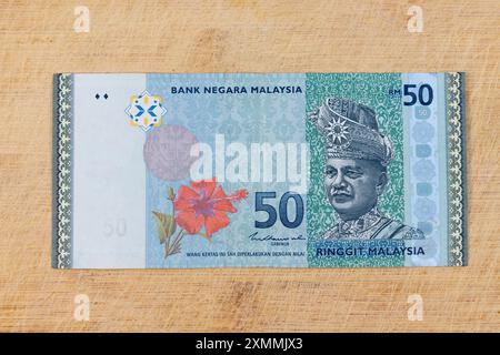 Le billet de banque malaisien de 50 ringgit de couleur bleue et verte sur fond de bois Banque D'Images