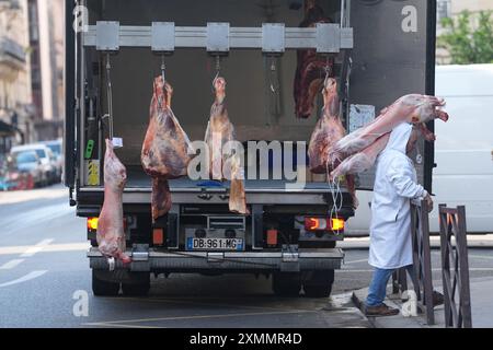 Paris, France. 29 juillet 2024. Olympia, Paris 2024, un homme transporte des morceaux de viande dans un restaurant. Crédit : Marcus Brandt/dpa/Alamy Live News Banque D'Images