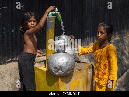 Des filles bangladaises ramassent de l'eau à la pompe à Sundarbans, Khulna Division, Shyamnagar, Bangladesh Banque D'Images