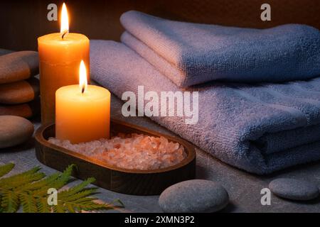 Composition de spa avec des bougies, du sel de mer et des serviettes sur fond gris Banque D'Images