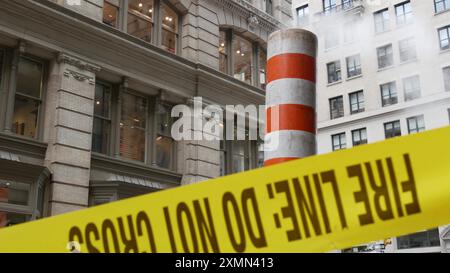 Vapeur évacuée sur New York City Street, cheminée de tubes de vapeur orange. Fumée chaude provenant du tuyau. CON Edison's Steam Operations System, 5 Fifth Avenue, Manhattan Midtown. Ne croisez pas le ruban d'avertissement jaune. Banque D'Images