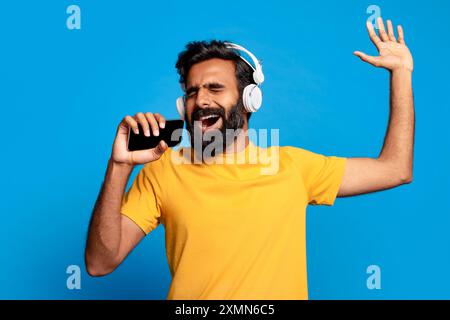 Homme chantant en musique avec casque allumé Banque D'Images