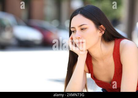 Triste femme asiatique pensive regardant dans la rue Banque D'Images