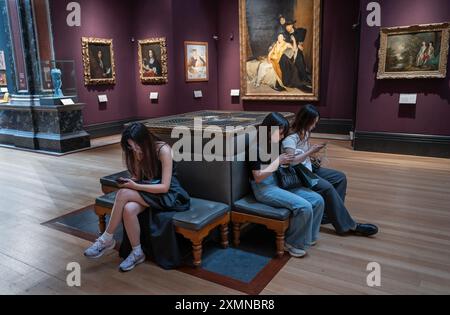 Fitzwilliam Museum Galerie d'art Cambridge UK visiteurs sur leur téléphone portable dans la galerie d'art. Banque D'Images