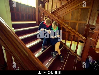 Deux écolières roedeennes comparent les notes entre les leçons sur le grand escalier. Roedean School , à la périphérie de Brighton , East Sussex 18 février 2000 photo de Roger Bamber Banque D'Images