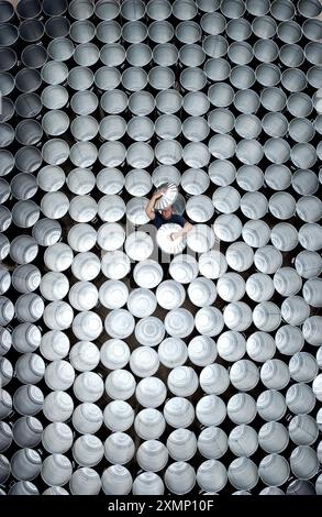 Photo de Roger Bamber : 12 septembre 2002 : Luke Cresswell, leader du groupe de percussion 'Stomp' trie quelques-unes des 1 110 poubelles expédiées chaque année aux trois compagnies qui tournent aux États-Unis et deux en Europe. Le groupe qui joue des poubelles ainsi que des balais, des pédalettes, des briquets Zippo, des pare-chocs de voiture à barils de pétrole, ou tout ce qui fait du rythme, ouvrira au Théâtre Vaudeville le 24 septembre pour 20 semaines. Ils viennent également de terminer un film 'Pulse' qui sera présenté en première au National History Museum, New York en octobre. Les poubelles galvanisées sont faites par Garrods de Barking..... Pour plus d'informations, contactez Banque D'Images