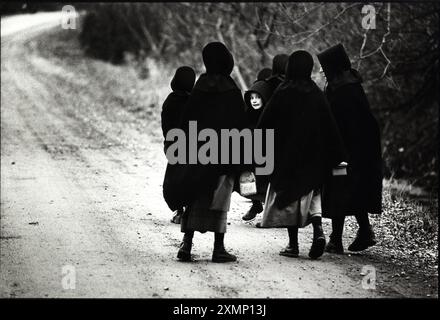 Enfants amish dans la vallée de Conewango, État de New York, États-Unis, en 1989. À seulement 300 miles au nord de New York, les enfants Amish étaient frappés par une épidémie de coqueluche. Les Amish, qui fuyaient les médicaments et les vaccins modernes, traitaient les enfants avec du jus de citron et du miel et trois bébés sont morts, devenant les premiers décès liés à la coqueluche en Amérique depuis trois ans. Les Amish ont normalement fui les caméras aussi bien, donc cette photo a été prise à distance sur un objectif de 30mm. Une petite fille ne pouvait pas résister à regarder ce qui se passait. Publié dans The mail le dimanche de janvier 1989. Banque D'Images