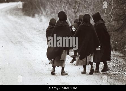 Enfants amish dans la vallée de Conewango, État de New York, États-Unis, en 1989. À seulement 300 miles au nord de New York, les enfants Amish étaient frappés par une épidémie de coqueluche. Les Amish, qui fuyaient les médicaments et les vaccins modernes, traitaient les enfants avec du jus de citron et du miel et trois bébés sont morts, devenant les premiers décès liés à la coqueluche en Amérique depuis trois ans. Les Amish ont normalement fui les caméras aussi bien, donc cette photo a été prise à distance sur un objectif de 30mm. Une petite fille ne pouvait pas résister à regarder ce qui se passait. Publié dans The mail le dimanche de janvier 1989. Banque D'Images