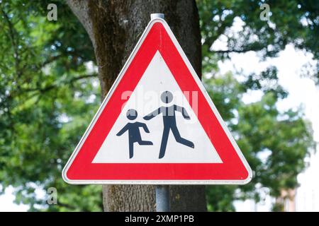 Dormagen 29.07.2024 Verkehrsschild Schulweg spielende Kinder Achtung Warnung Warnhinweis für Autofahrer Verkehrsteilnehmer Schule Vorfahrt Strassenverkehrsschild Strassenschild Kleinkind Elternteil Vater Mutter Familie Dormagen Nordrhein-Westfalen Deutschland *** Dormagen 29 07 2024 panneau de signalisation voie école jouer enfants attention avertissement pour les conducteurs usager de la route école droit de passage panneau routier panneau routier enfant parent père mère famille Dormagen Rhénanie du Nord-Westphalie Allemagne Banque D'Images